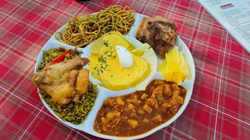 a plate of food with meat and vegetables on a table at Hospedaje El Cascabel in Sunampe