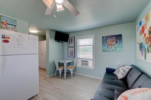 a living room with a couch and a refrigerator and a table at Barefoot Bungalow SPV26 in Port Aransas