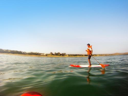 a person on a paddle board in the water at Vichayito Bungalows & Carpas by Aranwa Hotels in Vichayito