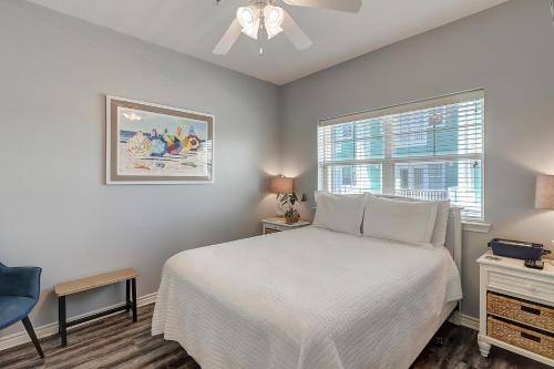 a bedroom with a white bed and a window at Barefoot Retreat MC15 in Port Aransas