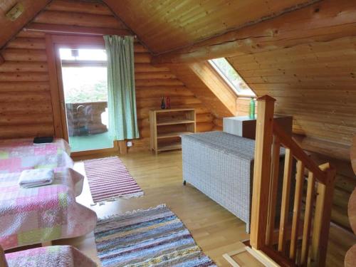 a room in a log cabin with a bed and a window at Saunaga külalistemaja, Tartust 9km kaugusel 