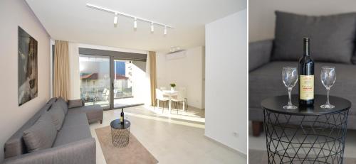 a living room with a couch and wine glasses on a table at Solaris Lux Apartments in Kotor