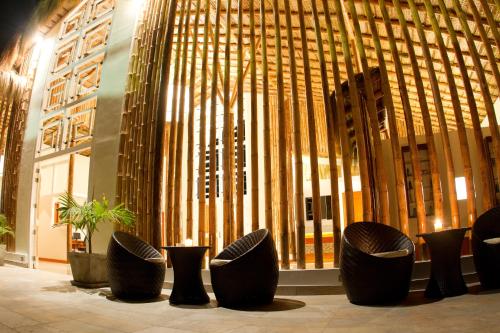 a lobby with black chairs and a large building at Vichayito Bungalows & Carpas by Aranwa Hotels in Vichayito