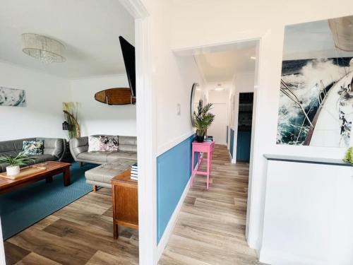 a living room with a couch and a table at Palms34 5 minute walk to beach Bungalow in Westward Ho