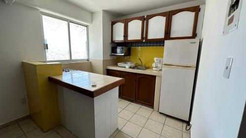a kitchen with a white refrigerator and a sink at Hotel Suites Regina in Veracruz