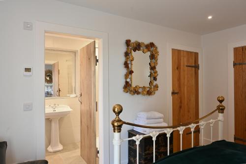 een badkamer met een wastafel en een spiegel aan de muur bij Capercaillie Cottage - Luxury converted steading in Perth