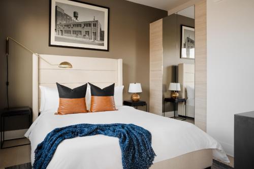 a bedroom with a large white bed with orange pillows at Sonder The Mint in Philadelphia