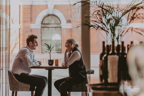 un homme et une femme assis à une table dans l'établissement Hotel Rialto, à Victoria