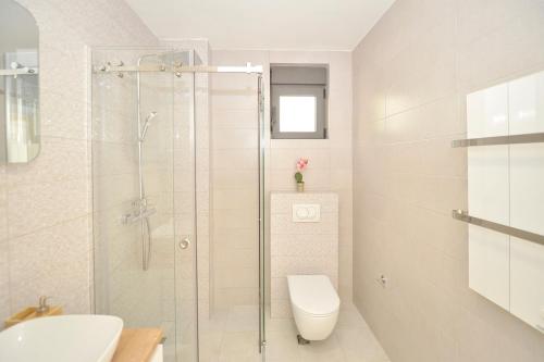 a bathroom with a toilet and a glass shower at Solaris Lux Apartments in Kotor