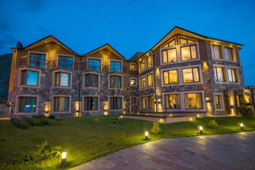 a large house with lights on the lawn at Chalten Suites Hotel in El Chalten