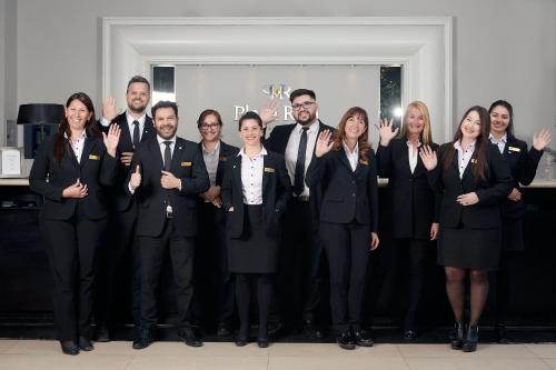 a group of people in suits posing for a picture at Plaza Real Suites Hotel in Rosario