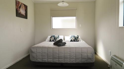 a bedroom with a bed with a teddy bear on it at Taupo Debretts Spa Resort in Taupo