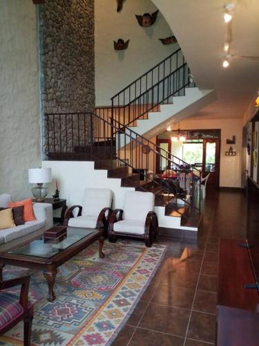 a living room with white furniture and a staircase at Vista Gaital/ Gaital View in Antón