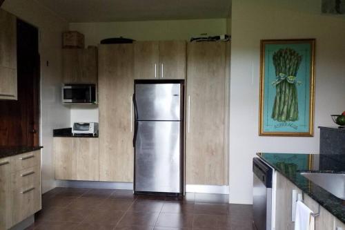 a kitchen with a stainless steel refrigerator and wooden cabinets at Vista Gaital/ Gaital View in Antón
