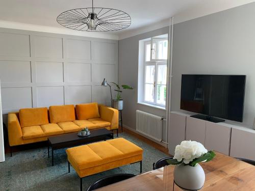 a living room with a couch and a tv at Boutique Gästehaus Guestel in Krems an der Donau