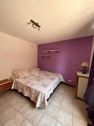 1 dormitorio con cama y pared púrpura en Departamento Belgrano Godoy Cruz en Godoy Cruz