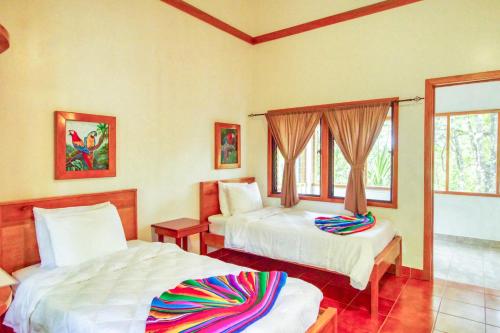 a bedroom with two beds and a window at Mariposa Jungle Lodge in San Ignacio
