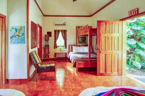 a room with a bedroom with a bed and a open door at Mariposa Jungle Lodge in San Ignacio