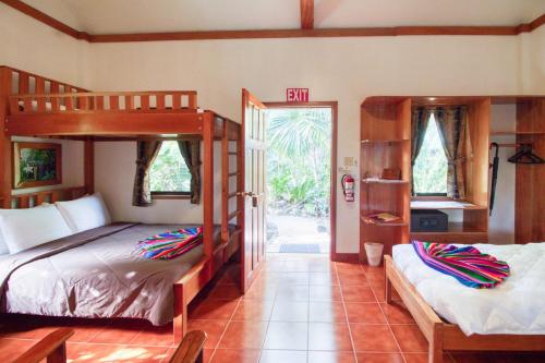 a bedroom with two bunk beds and a open door at Mariposa Jungle Lodge in San Ignacio