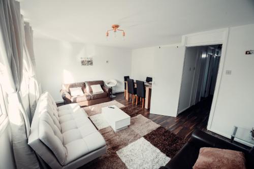 a living room with a white couch and a table at Comfy Home-Wood Green in London