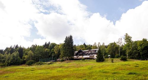 a large house on a hill in a field at Svycarska Bouda in Špindlerův Mlýn