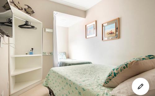 a small bedroom with a bed and shelves at Geribá Apart Hotel Internacional Buzios in Búzios