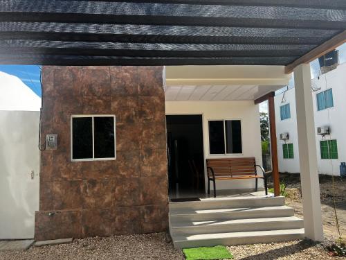 a house with a wooden door and a bench at Cabaña confortable y familiar in Coveñas