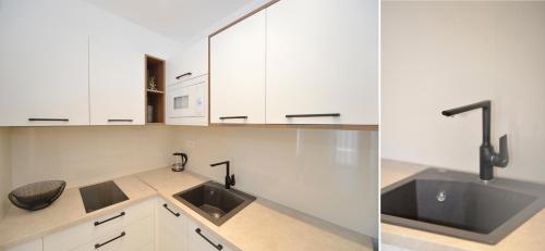 a kitchen with white cabinets and a sink at Solaris Lux Apartments in Kotor