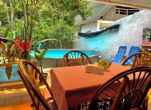 een patio met een tafel en stoelen en een zwembad bij EL RODEO in San Gil