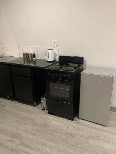 a kitchen with a black stove and a refrigerator at Little Heaven in Johannesburg