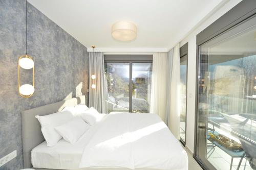 a bedroom with a white bed and a balcony at Solaris Lux Apartments in Kotor