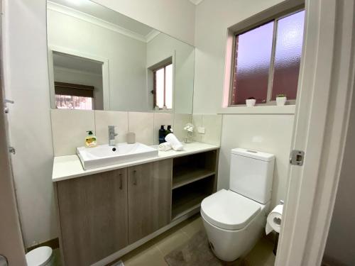 een badkamer met een wit toilet en een wastafel bij Gardens Vista Villa in Lyndhurst