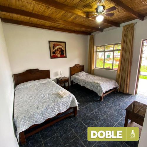 a bedroom with two beds and a window at Hospedaje El Cascabel in Sunampe