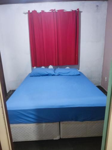uma cama num quarto com uma cortina vermelha em Mangue House lll no Rio de Janeiro