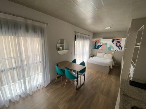 1 dormitorio con mesa, sillas y 1 cama en 66 Cozy new studio near Paulista, en São Paulo