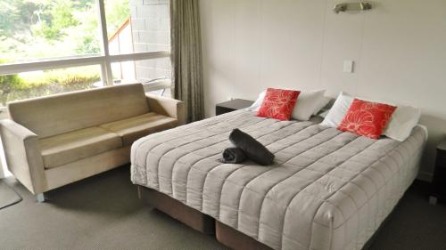 a bedroom with a bed with a cat laying on it at Taupo Debretts Spa Resort in Taupo