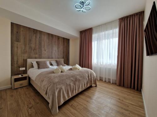 a bedroom with a large bed and a window at Dendrarium Park Apartment Deluxe in Chişinău