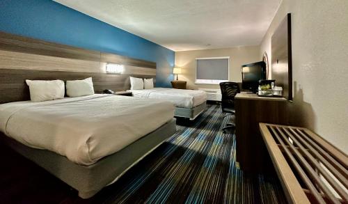 カンザスシティにあるBaymont by Wyndham Kansas City KU Medical Centerのベッド2台とテレビが備わるホテルルームです。