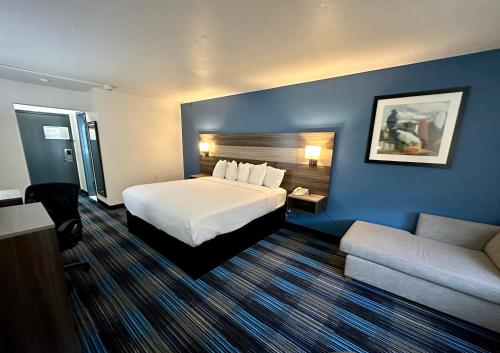 a hotel room with a bed and a couch at Baymont by Wyndham Kansas City KU Medical Center in Kansas City