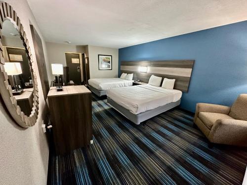 a hotel room with two beds and a couch at Baymont by Wyndham Kansas City KU Medical Center in Kansas City
