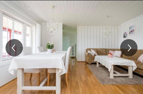 a living room with a white table and a couch at Strandhytte ved fjorden in Molde