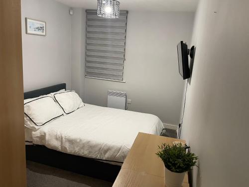 a small bedroom with a bed and a table at City centre apartment in Manchester