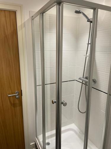 a shower with a glass door in a bathroom at City centre apartment in Manchester