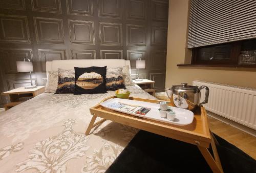 a bed with a tray on top of it with a table at Spacious house City skyline and mountain views close too belfast centre and airports free parking in Belfast