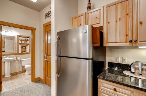 una cocina con nevera de acero inoxidable y armarios de madera en Expedition Station Condominiums by Keystone Resort, en Keystone