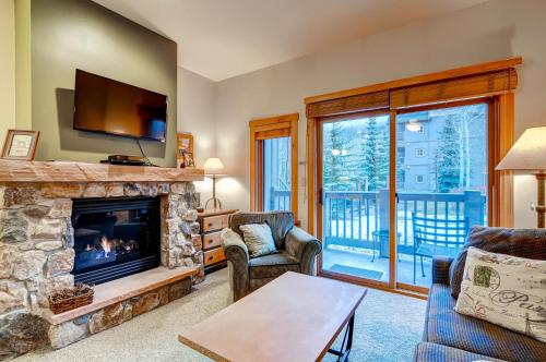 a living room with a fireplace and a tv at Expedition Station Condos by Vail Resorts in Keystone