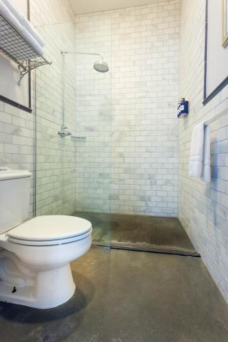 a bathroom with a toilet and a glass shower at Argos Inn - Ithaca's Boutique Hotel in Ithaca