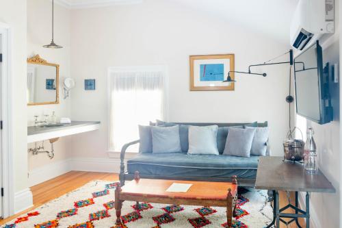 a living room with a blue couch and a table at Argos Inn - Ithaca's Boutique Hotel in Ithaca