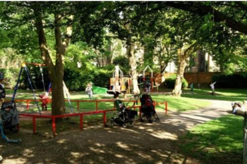 a park with a playground with a swing at Victorian Building turned Charming Hotel Perfect For Short and Long Term Stay with WiFi in London
