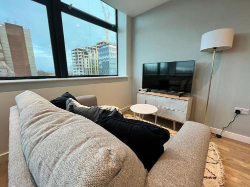 uma sala de estar com um sofá e uma televisão de ecrã plano em Fantastic one bedroom apartment near Old Trafford Stadium em Manchester